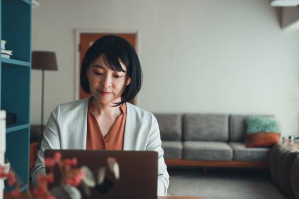 3.salud laboral. mujer con bata dando consulta por computadora 